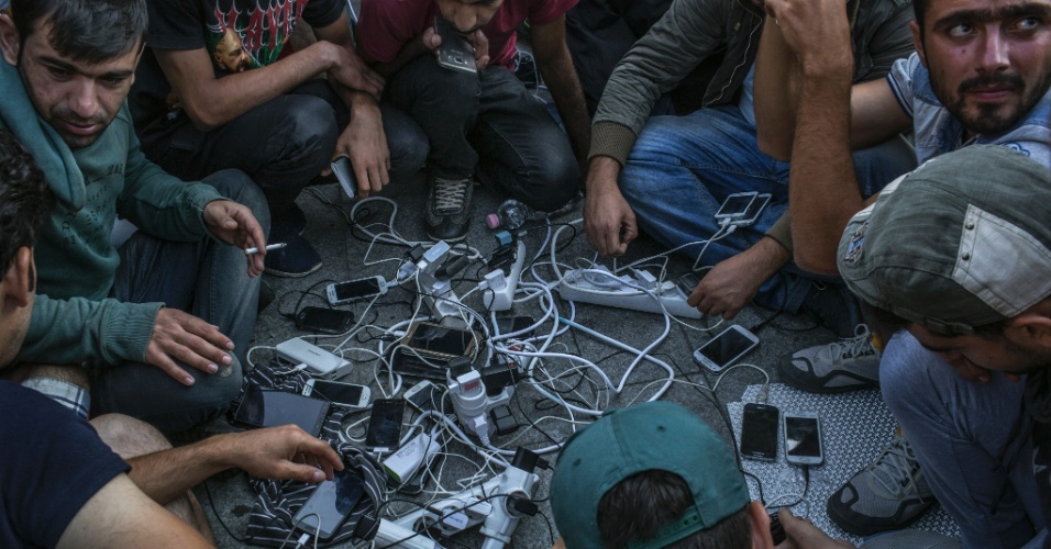 2.set.2015 - Refugiados carregam seus celulares usando o gerador de uma estação de TV, do lado de fora da estação ferroviária de Keleti, em Budapeste, na Hungria. A foto foi tirada em 2 de setembro