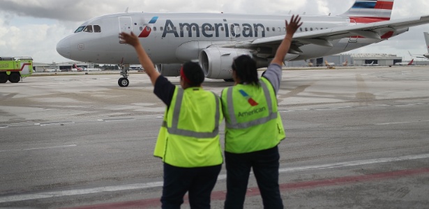 Funcionários acenam para o voo 903 da American Airlines que decola do aeroporto de Miami, na Flórida, em direção a Cienfuegos, em Cuba - Joe Raedle/Getty Images/AFP