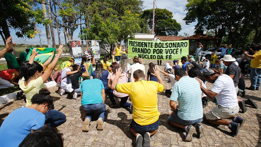 Apoiadores do presidente eleito oram em frente à residência oficial da Granja do Torto, em Brasília, onde Bolsonaro está com a família, neste domingo (30) - Dida Sampaio/Estadão Conteúdo