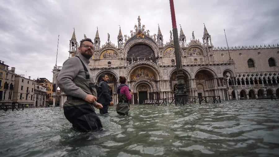 15.nov.2019 - Pessoas caminham pela praça de São Marcos, em Veneza, após inundação - Filippo Monteforte/AFP