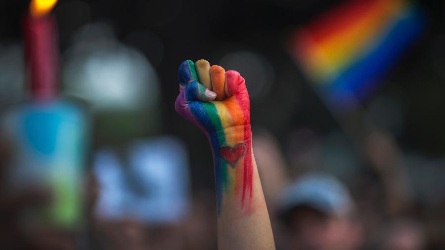 Punho erguido com as cores da bandeira LGBT e o desenho de um coração - David McNew/Getty Images