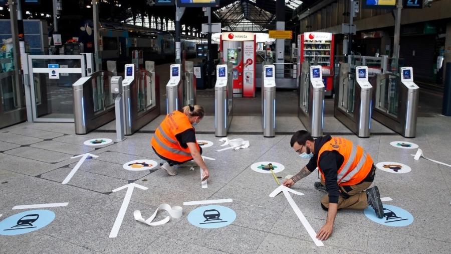 Com fitas, funcionários marcam distância necessária para evitar disseminação do coronavírus em estação do metrô de Paris, na França - Chesnot/Getty Images