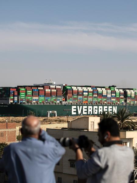 29 mar. 2021 - Pessoas assistem ao "Ever Given" voltar a navegar pelo Canal de Suez, no Egito, após ser totalmente liberado - Mahmoud Khaled/Getty Images