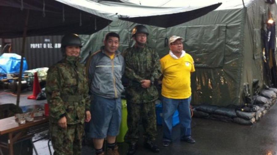 Miguel Kamiunten (de cinza), junto a militares nos abrigos após terremoto de Tohoku em 2011 - Arquivo pessoal