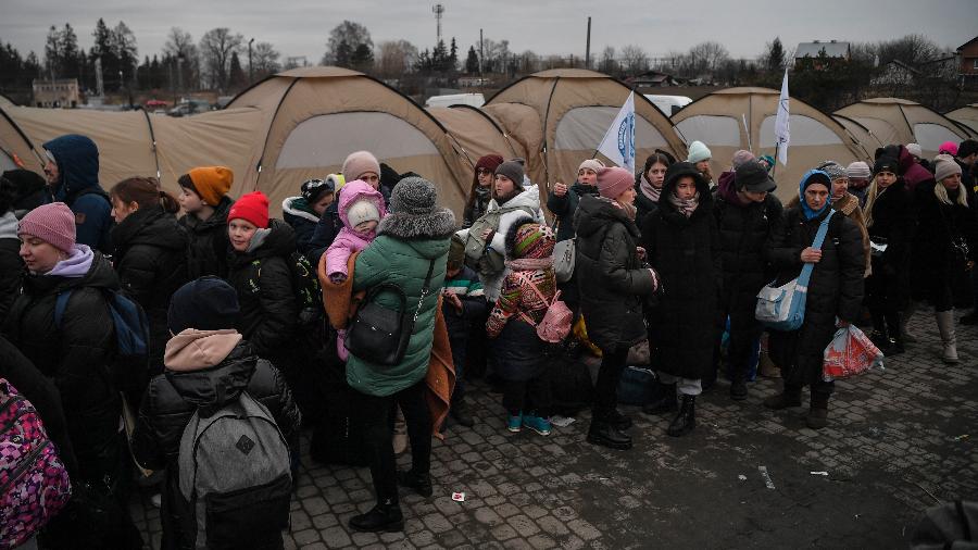 09.mar.22 - Refugiados ucranianos aguardam transporte após cruzarem a fronteira com a Polônia na cidade de Medyka - Louisa Gouliamak/AFP