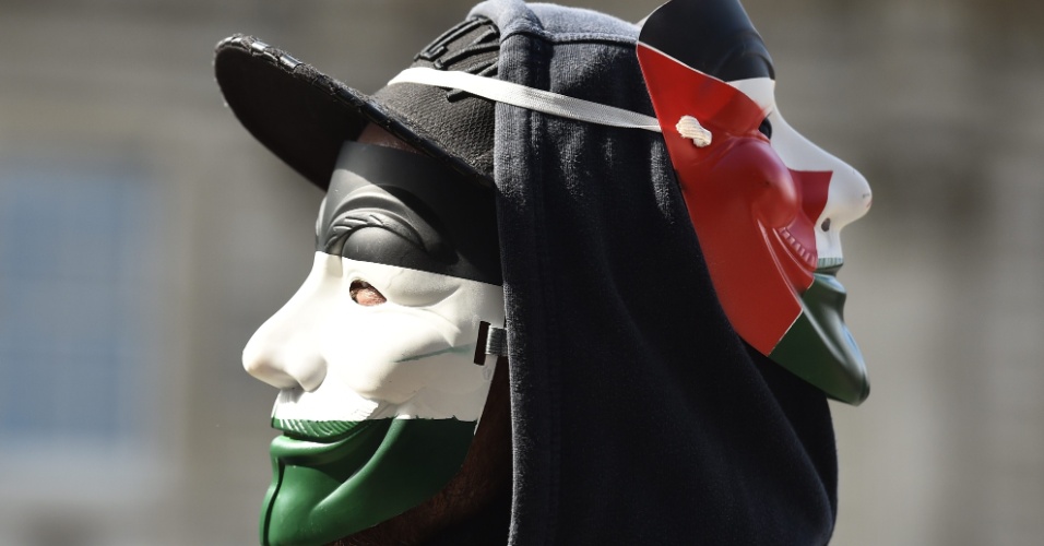 9.set.2015 - Manifestante usa máscara de Guy Fawkes pintada com as cores da bandeira palestina durante um protesto em Londres, Inglaterra