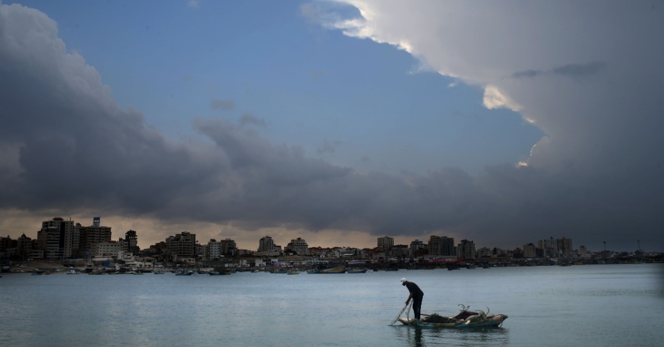 26.out.2015 - Pescador joga sua rede, com céu nublado ao fundo, na Cidade de Gaza (Palestina)