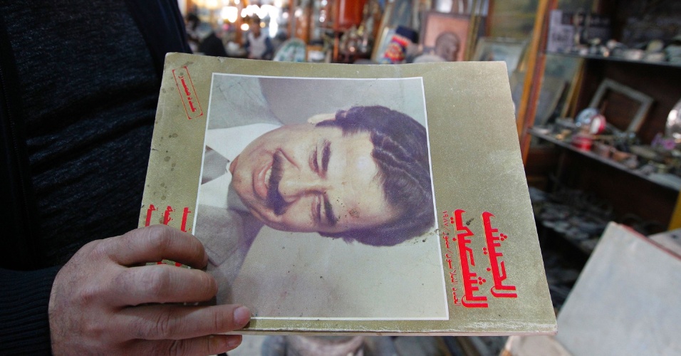 29.dez.2016 - Lojista segura livro com retrato do ditador falecido do Iraque, Saddam Hussein. Embora alguns considerem que o negócio é controverso, muitos frequentam a loja, 10 anos depois da morte de Hussein
