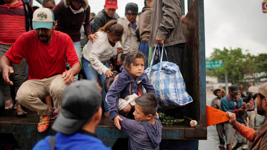 Migrantes saem de caminhão em Tierra Blanca, no México, durante viagem rumo aos EUA - Alexandre Meneghini/Reuters