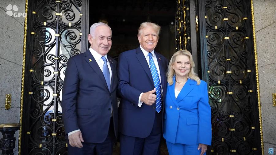 O primeiro-ministro de Israel, Benjamin Netanyahu, e sua esposa são recebidos pelo ex-presidente Donald Trump em seu resort - Handout / Israeli Government Press Office / AFP