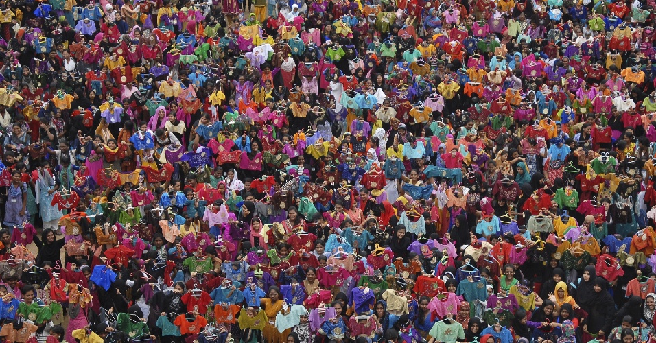09.out.2015 - Estudantes mostram algumas das sete mil camisas bordadas que foram pintadas, no período de um hora, na tentativa de quebra de recorde, em Chennai (Índia)