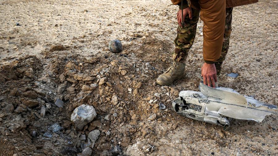 Um combatente palestino verifica os detritos no local de um ataque aéreo israelense em Khan Yunis, no sul da Faixa de Gaza - Said Khatib/Afp