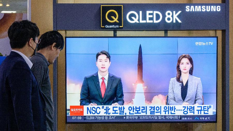 09.out.22 - Pessoas assistem a um noticiário mostrando imagens de arquivo de um teste de míssil norte-coreano, em uma estação ferroviária em Seul - ANTHONY WALLACE/AFP