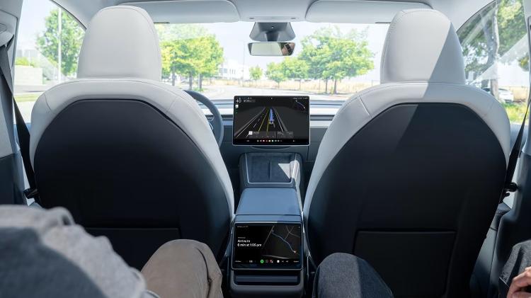 Traseira do Model Y como robotaxi; há uma tela na parte traseira do carro para poder acionar a corrida Traseira do Model Y como robotaxi; há uma tela na parte traseira do carro para poder acionar a corrida