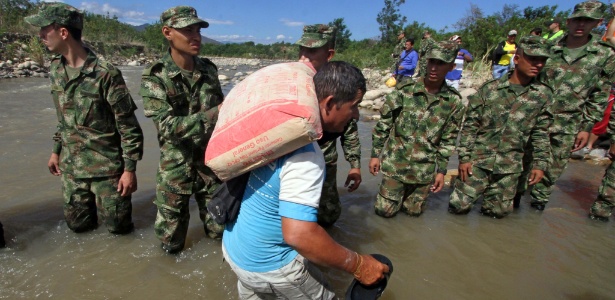 Soldados colombianos ajudam cidadão expulso a cruzar a fronteira com a venezuela - GEORGE CASTELLANOS/AFP
