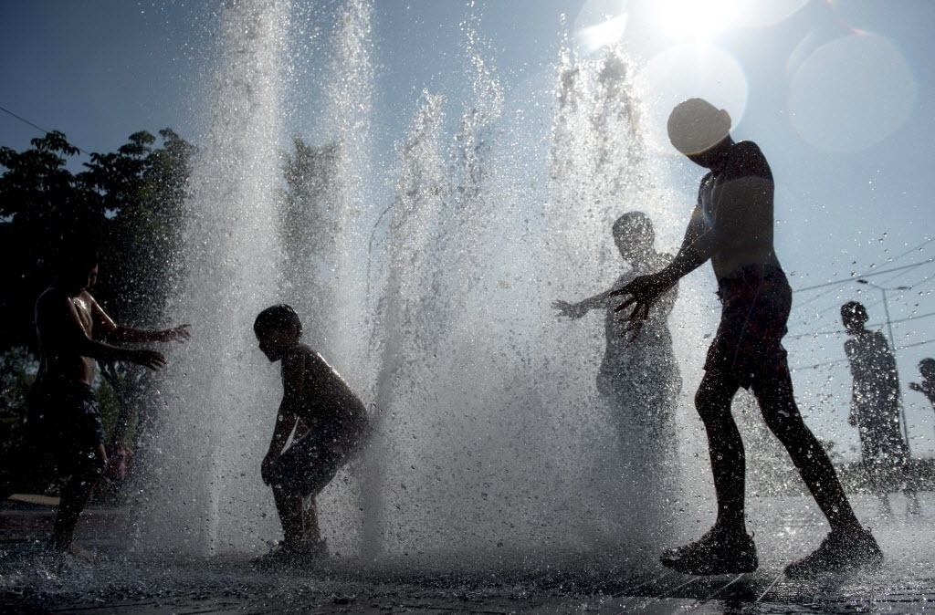 2.fev.2016 - Crianças brincam em uma fonte durante dia quente de verão na praça de Santiago, Chile 