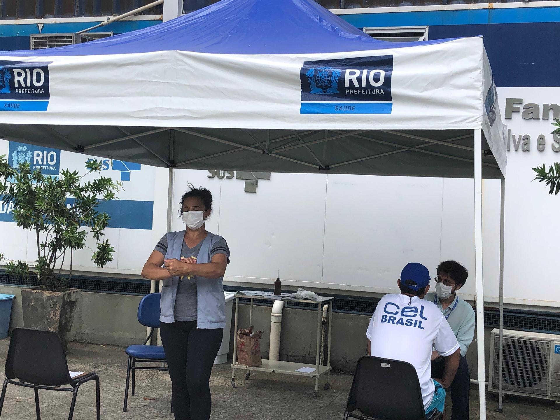 24.mar.2020 - Profissionais de saúde atentem o público em tenda colocada na parte externa da Clínica da Família da Rocinha para evitar disseminação do novo coronavírus - Herculano Barreto Filho/UOL