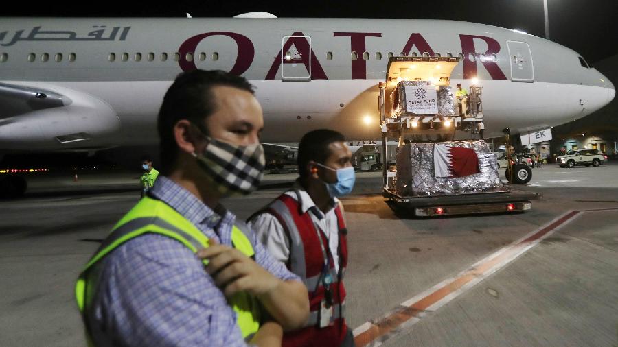 Funcionários do aeroporto internacional de Doha, no Qatar, usam máscara contra coronavírus - Karim Jaafar/AFP