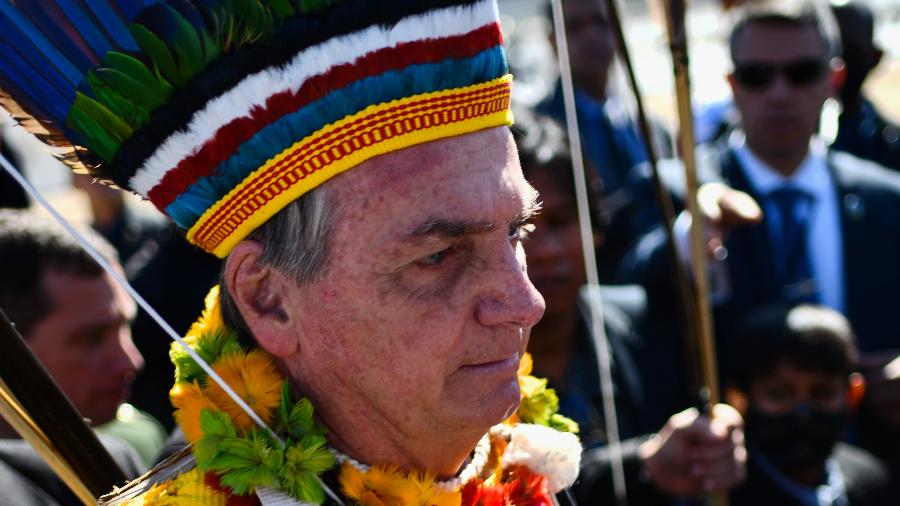 12.ago.2021 - O presidente Jair Bolsonaro com cocar indígena tira fotos na Praça dos Três Poderes, em Brasília - Mateus Bonomi/AGIF/Estadão Conteúdo