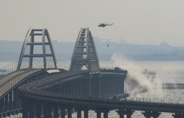 08.Oct.22 - Helicopter drops water to extinguish burning fuel tanks on Kerch Bridge, Kerch Strait, Crimea - STRINGER/REUTERS - STRINGER/REUTERS