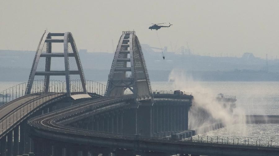 Helicóptero joga água para extinguir tanques de combustível em chamas na ponte de Kerch, no Estreito de Kerch, Crimeia - STRINGER/REUTERS