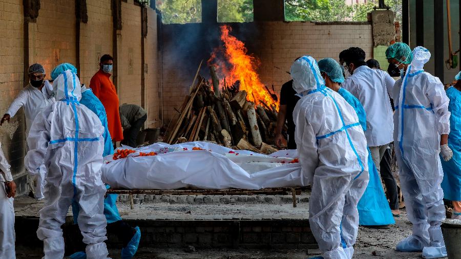 Funcionários protegidos preparam corpo no crematório em Bangalore, na Índia - EFE/EPA/JAGADEESH