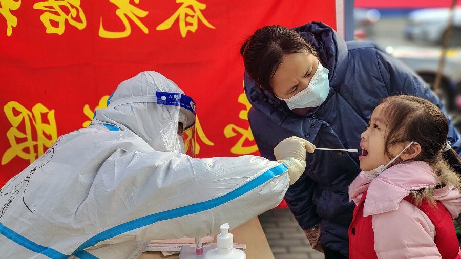 Criança passa por posto de testagem na cidade chinesa de Anyang - 11.jan.2022 - Ma Xiaoran/Xinhua