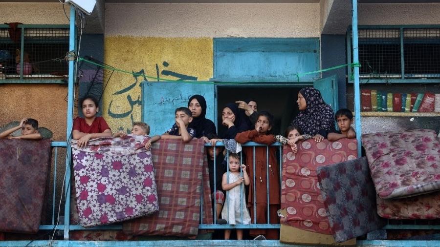 Palestinos deslocados abrigados na escola da ONU Al-Jawni (Jaouni) observam depois que um ataque aéreo israelense atingiu o local, em Nuseirat, na Faixa de Gaza central, em 11 de setembro de 2024