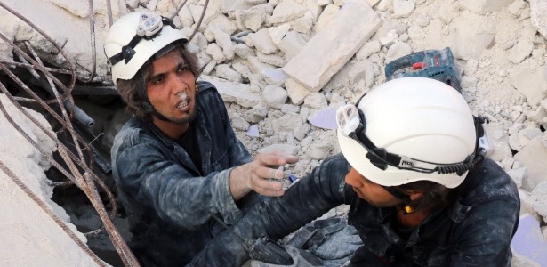 30.out.2015 - Equipes de resgate procuram sobreviventes sob escombros após um ataque aéreo em Aleppo - Thaer Mohammed/AFP