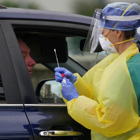 Profissional da saúde faz teste para coronavírus num drive thru montado em Bondi Beach, em Sydney, na Austrália - Loren Elliott/Reuters