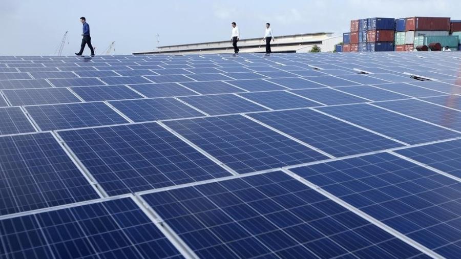 O CEO da Sun Electric, Matthew Peloso (esq.), caminha entre os painéis solares no telhado de uma fábrica em Cingapura - Reuters