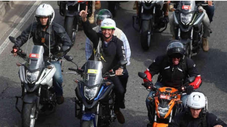 Bolsonaro no obsceno desfile de motocicletas havido no domingo, no Rio, alheio à realidade da doença e promovendo comportamento de risco - Pilar Olivares/Reuters