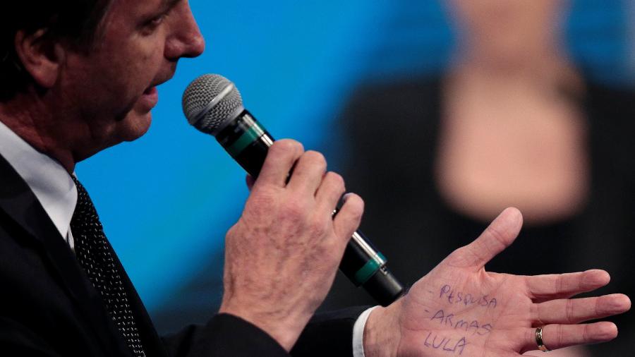 Bolsonaro lê cola nas mãos em debate de 2018 com palavras Lula, pesquisas e armas - Paulo Whitaker - 17.ago.2018/Reuters