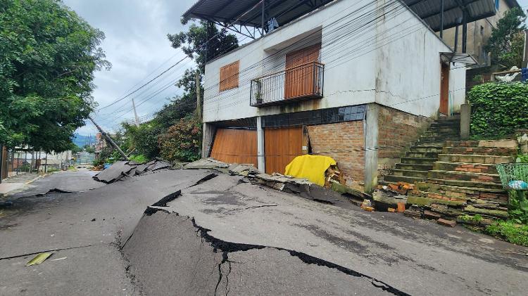 18.mai.2024 - Com deslizamento de terra, asfalto da rua Guilherme Dal Ri, em Gramado (RS), pressionou portão de casa