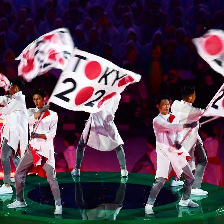 Dançarinos exibem bandeira da Tóquio-2020 - AFP PHOTO / Jim WATSON