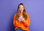 Os 5 artigos mais lidos no MacMagazine: de 25 de agosto a 1º de setembro - Garota feliz/excitada usando um iPhone 15