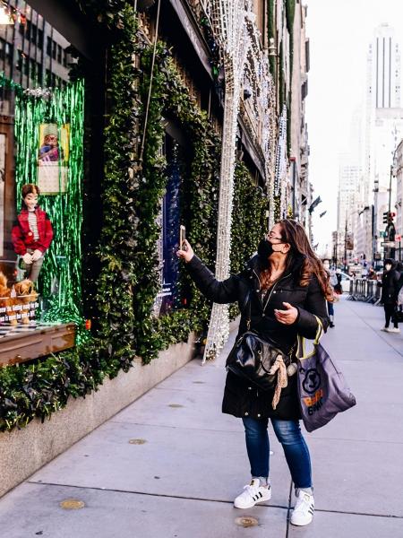 Pedestre usando máscara de proteção contra o coronavírus passa por vitrine de loja decorada para o Natal em Nova York, nos EUA - Bloomberg