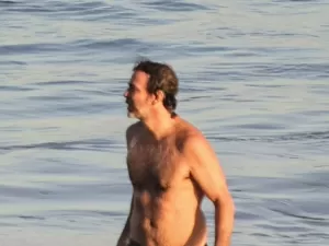 No ar em Alma Gêmea, Marcelo Faria ajeita a sunga e causa frisson na praia
