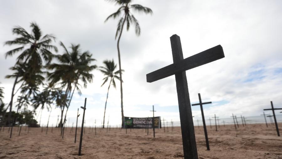 Cruzes fincadas em praia do Recife para lembrar mortos pela covid-19 no Brasil                              -                                 BRUNO CAMPOS/JC IMAGEM                            