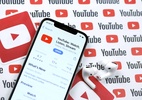 Como desativar a exibição de cards de informações no YouTube [iPhone e iPad] - iPhone com app do YouTube em mesa com AirPods Pro ao lado