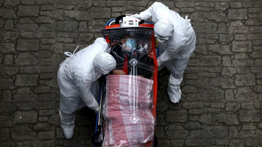OMS alerta: próxima pandemia pode ser mais grave que COVID-19 - Profissionais de saÃºde em Seul, na Coreia do Sul, transferindo um paciente com COVID-19 de uma ambulÃ¢ncia para um hospital em marÃ§o. Foto: Chung Sung-Jun (Getty Images)