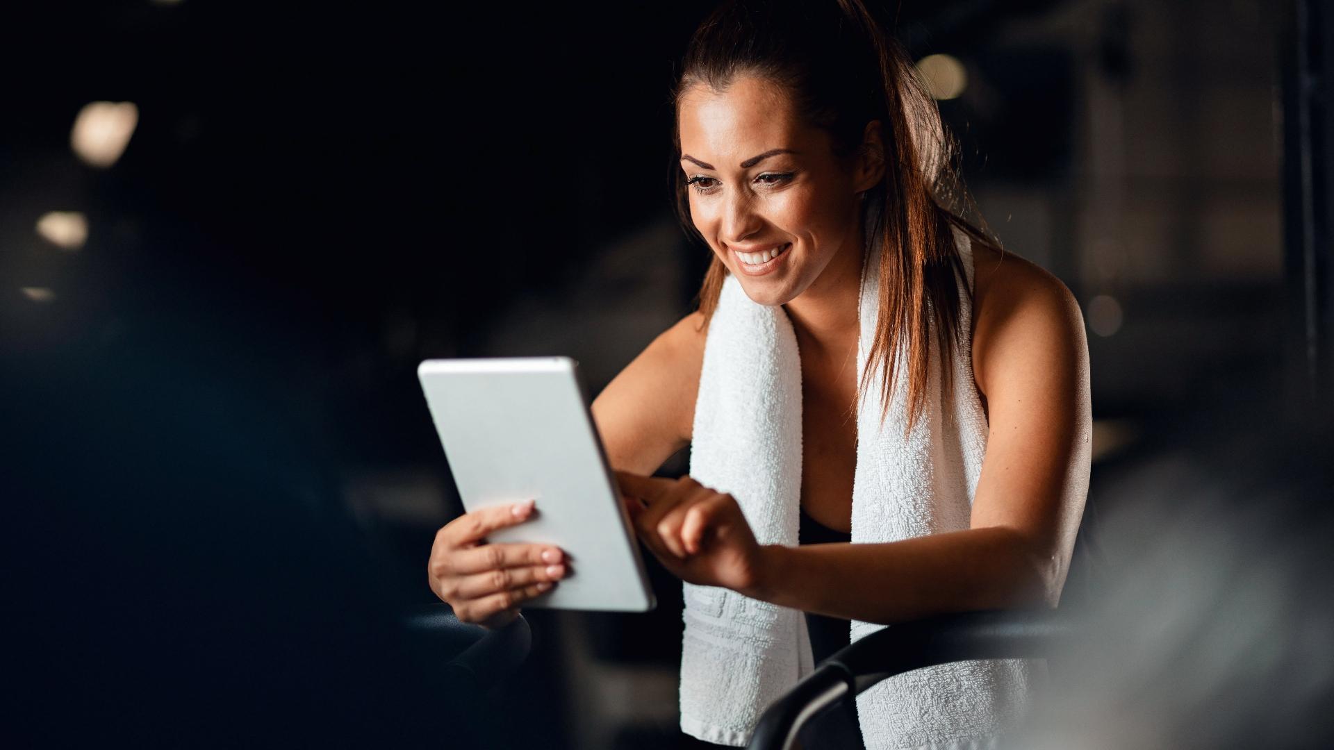 Imagem de uma mulher durante treino segurando tablet - undefined