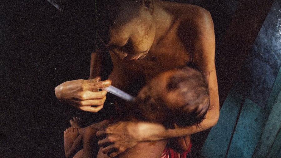 Yanomami tenta alimentar criança desnutrida. Terra indígena foi invadida por garimpeiros ilegais - Urihi Yanomami