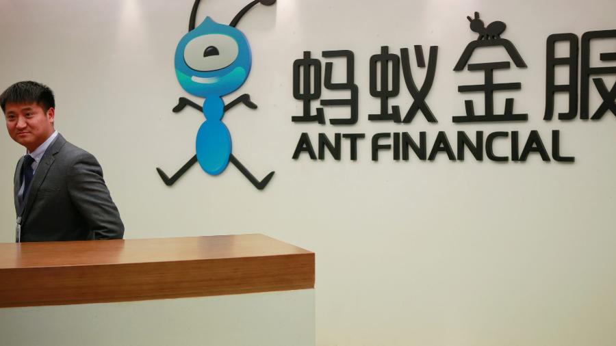 Funcionário ao lado do logotipo da Ant Financial Services Group, fintech da gigante chinesa Alibaba - Shu Zhang/Reuters