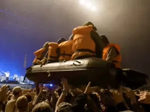 Vídeo: Em nova performance de Banksy, bote de imigrantes 'navega' sobre a plateia de Glastonbury