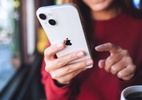 iOS 18: usuários relatam ter ouvido vozes misteriosas em seus iPhones - Mulher usando um iPhone 13