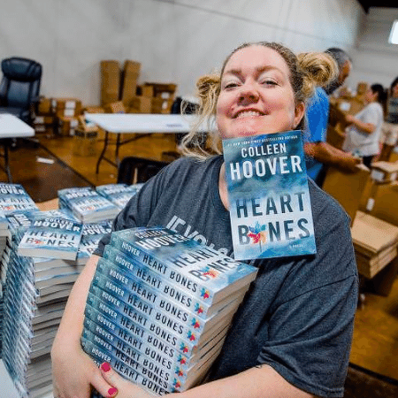 Colleen Hoover e sua pilha de livros: tudo que ela escreve vende muito - Divulgação