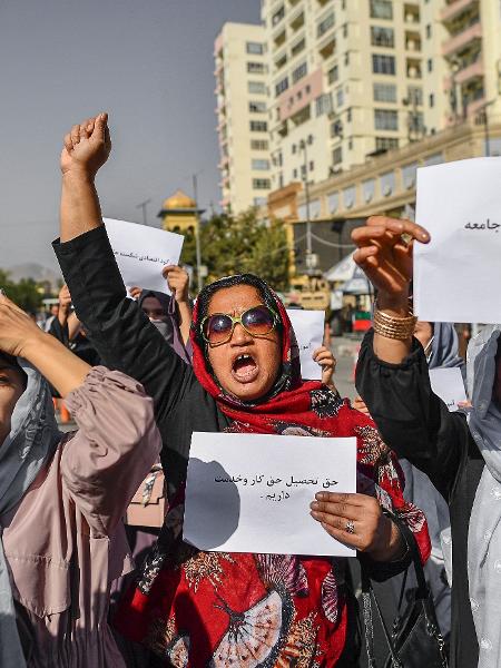 Mulheres afegãs seguram cartazes durante um protesto pelos direitos das mulheres em Cabul em 21 de outubro de 2021. Talibã reprimiu violentamente a cobertura da mídia - BULENT KILIC / AFP
