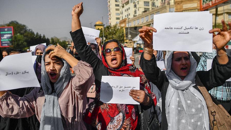 Mulheres afegãs seguram cartazes durante um protesto pelos direitos das mulheres em Cabul em 21 de outubro de 2021. Talibã reprimiu violentamente a cobertura da mídia - BULENT KILIC / AFP