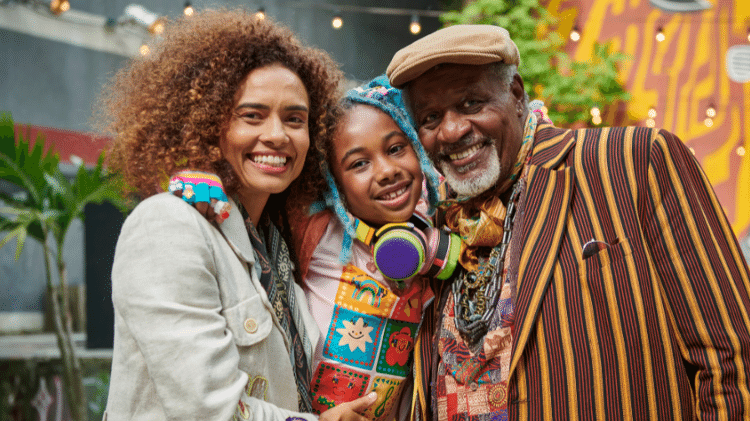 Balú (Lua Miranda), entre sua mãe (Aisha Jambo) e seu Vô Acácio (Tony Tornado)